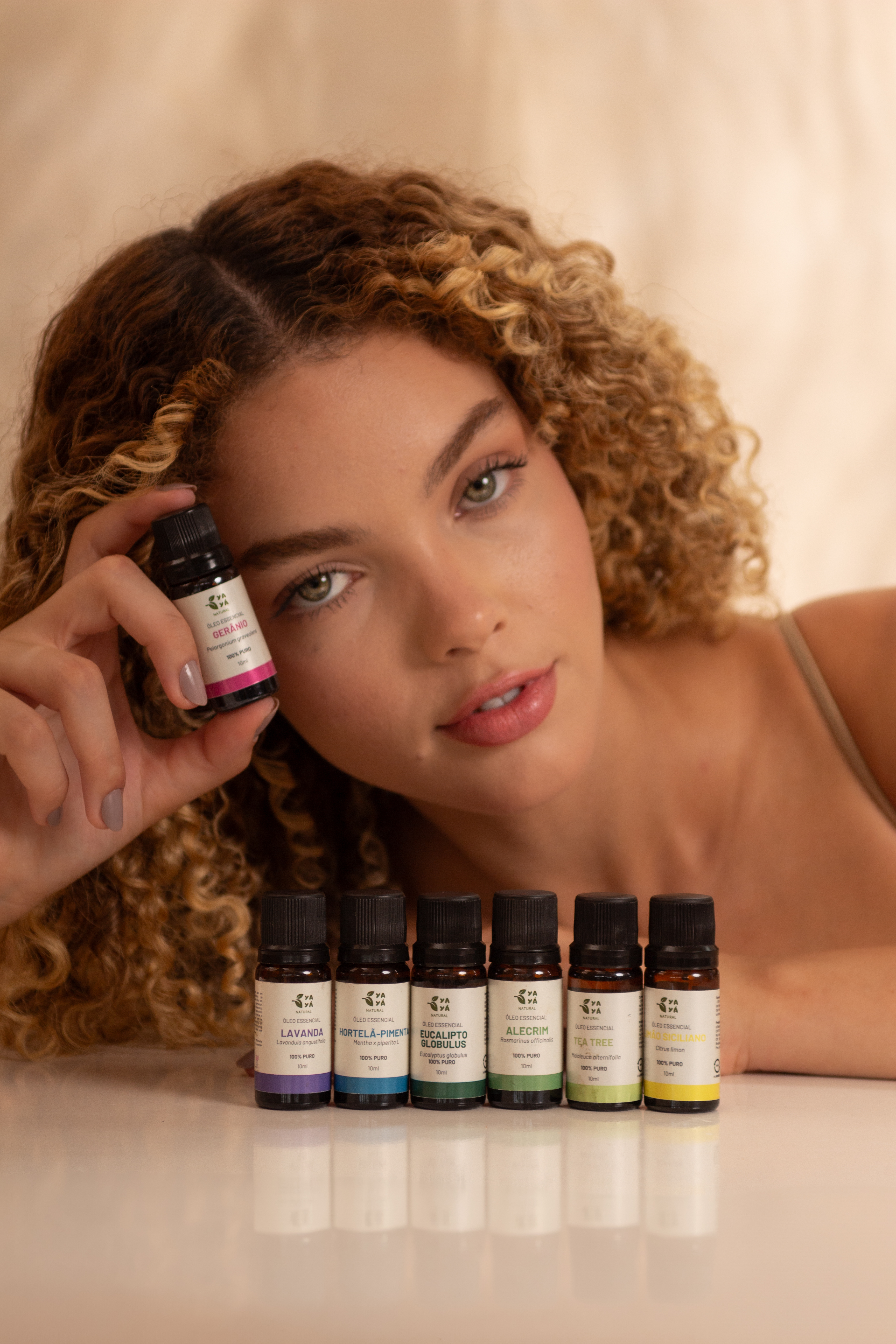 Linha de produtos Yayá Natural Cacau: duas latas, uma caixa, sachês individuais e um copo com bebida de cacau sobre fundo vermelho